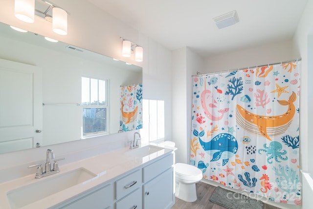 bathroom with visible vents, wood finished floors, a sink, and toilet