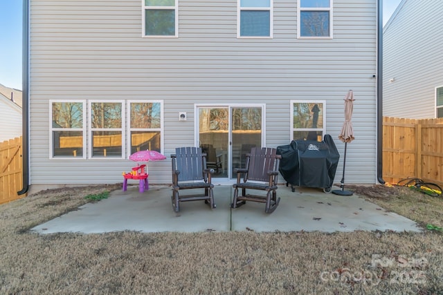 rear view of property featuring a patio and fence