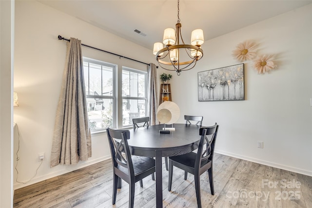 dining room with a chandelier, light hardwood / wood-style floors, and plenty of natural light