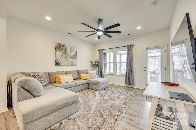 living room with ceiling fan and light wood-type flooring