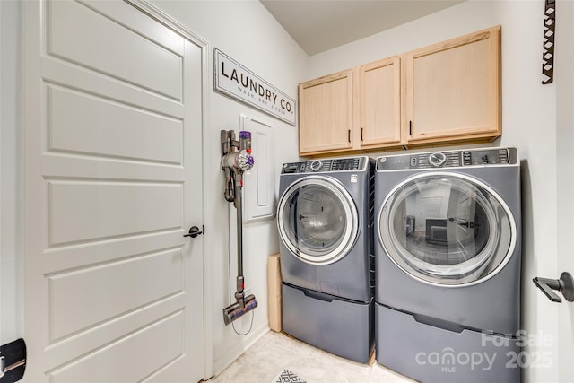 laundry room featuring washer and clothes dryer, light tile patterned flooring, and cabinets