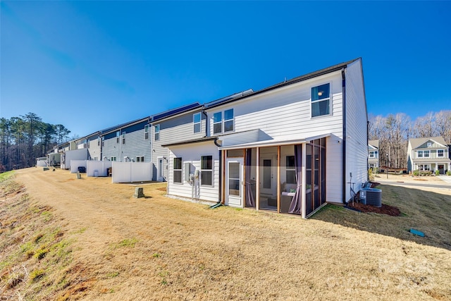 rear view of property featuring a sunroom and central AC unit