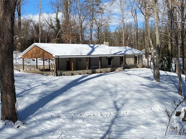 ranch-style house featuring a porch and a carport