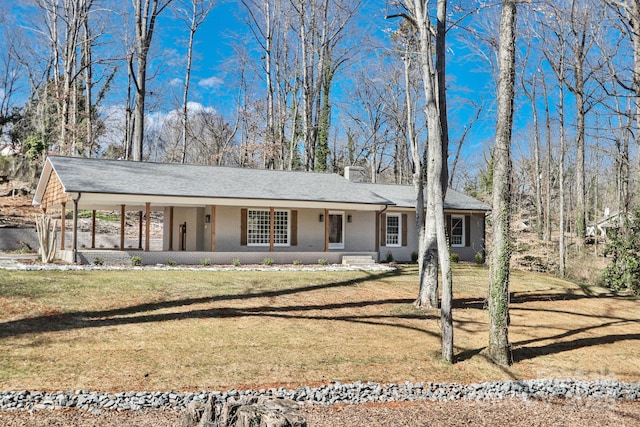 single story home featuring brick siding, a chimney, a porch, a carport, and a front lawn