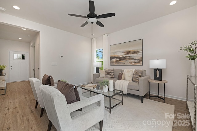 living room with light hardwood / wood-style flooring and ceiling fan