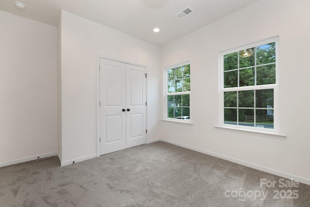 unfurnished bedroom featuring carpet flooring and a closet