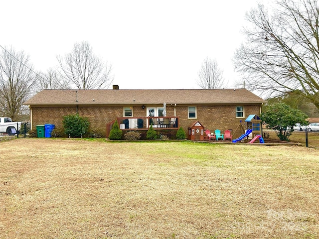 back of property featuring a lawn and a wooden deck