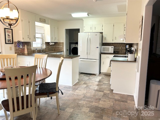 kitchen with white cabinets, washer / dryer, white appliances, and sink