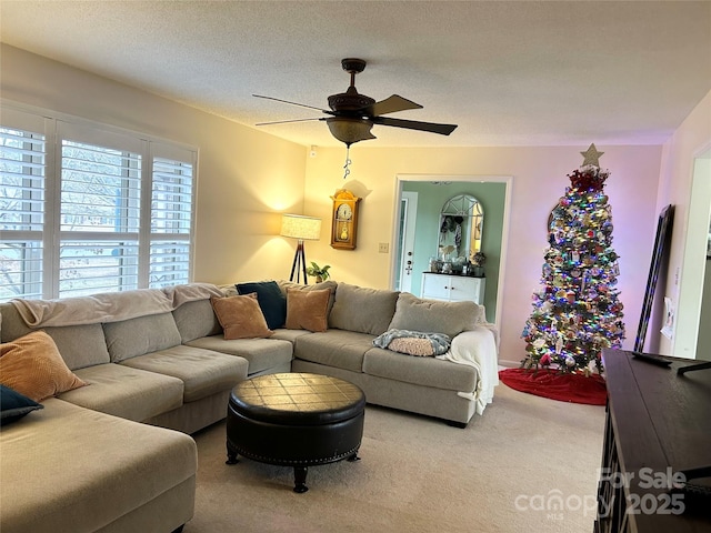 living room with carpet flooring, a textured ceiling, and ceiling fan