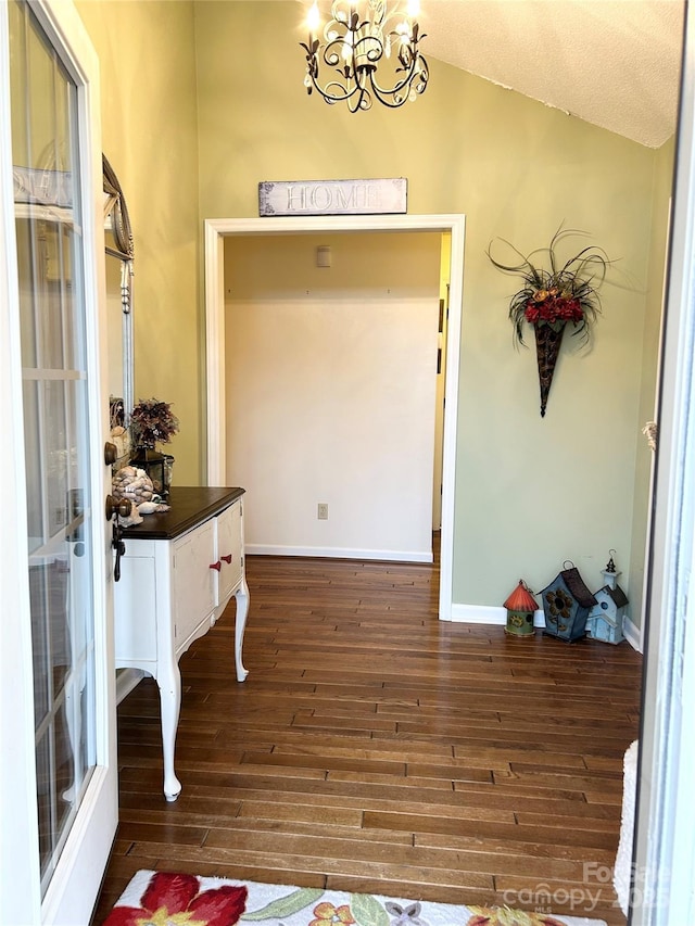 entryway with french doors, dark hardwood / wood-style flooring, lofted ceiling, and a notable chandelier