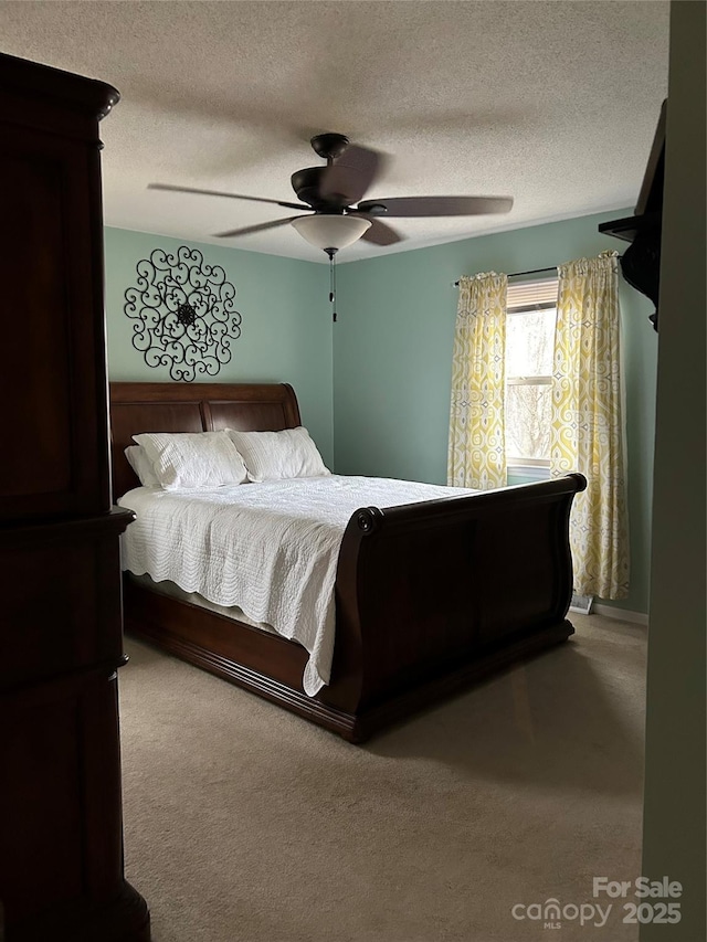 bedroom with carpet, ceiling fan, and a textured ceiling