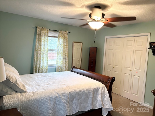 bedroom with ceiling fan, carpet floors, and a textured ceiling