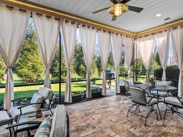 sunroom / solarium featuring plenty of natural light and ceiling fan