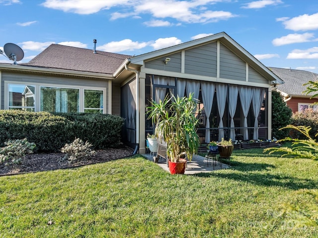 rear view of property with a yard and a sunroom