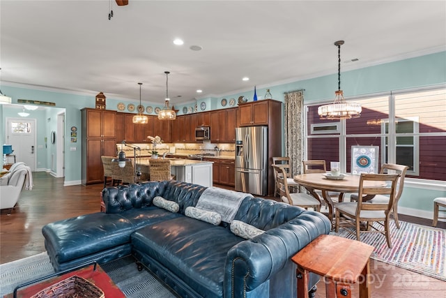 living room featuring crown molding, sink, dark hardwood / wood-style floors, and an inviting chandelier