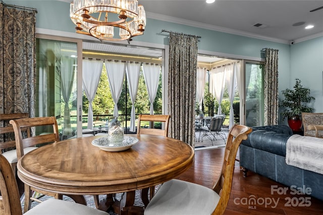 dining room featuring crown molding, dark wood-type flooring, and a chandelier