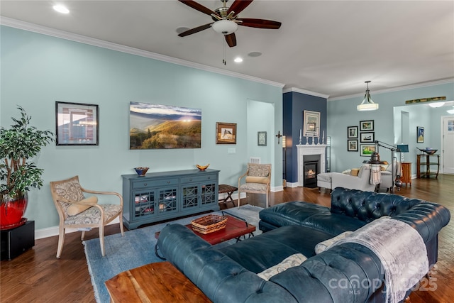 living room with ceiling fan, dark hardwood / wood-style flooring, and ornamental molding