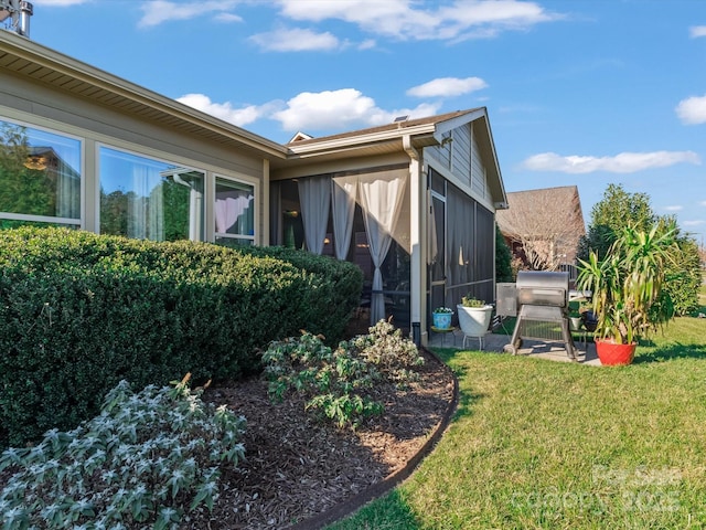 view of side of home featuring a yard and a sunroom