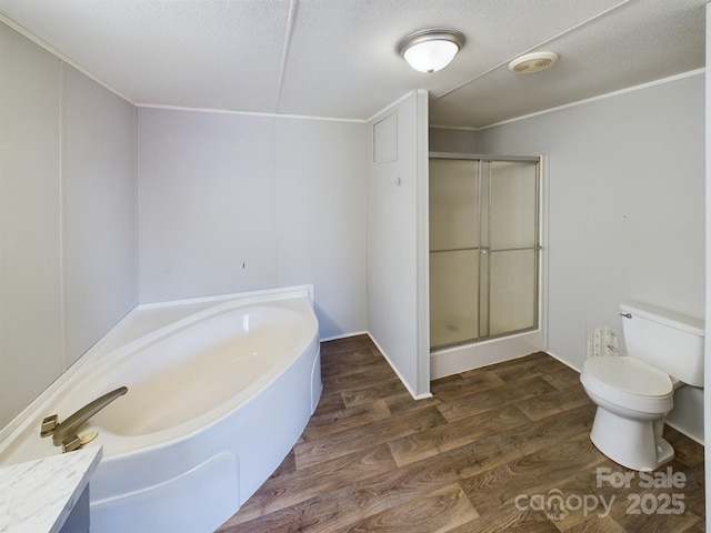 bathroom with a textured ceiling, wood-type flooring, plus walk in shower, and toilet