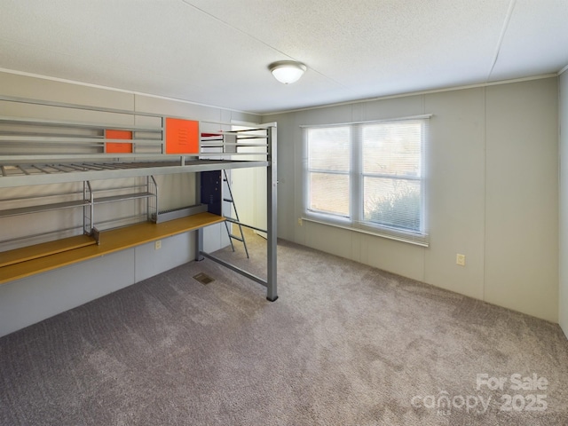 unfurnished bedroom with a textured ceiling and carpet