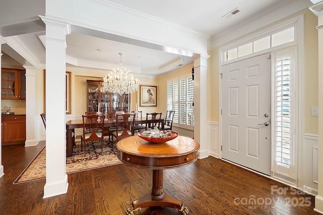 entrance foyer featuring crown molding, dark hardwood / wood-style floors, and an inviting chandelier