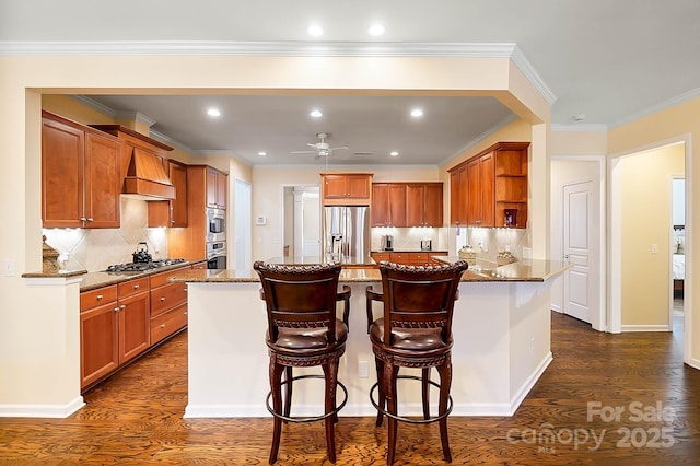 kitchen with premium range hood, decorative backsplash, light stone countertops, a kitchen bar, and stainless steel appliances