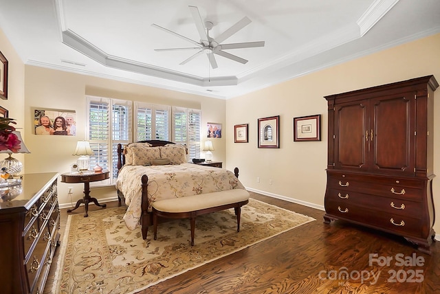 bedroom with dark hardwood / wood-style flooring, a tray ceiling, ceiling fan, and crown molding