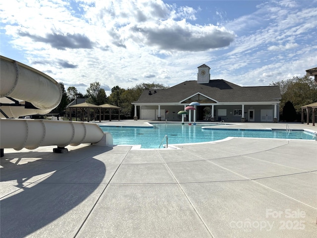 view of pool with a patio area and a water slide