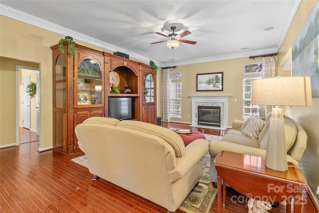 living room featuring a high end fireplace, a wealth of natural light, and ornamental molding