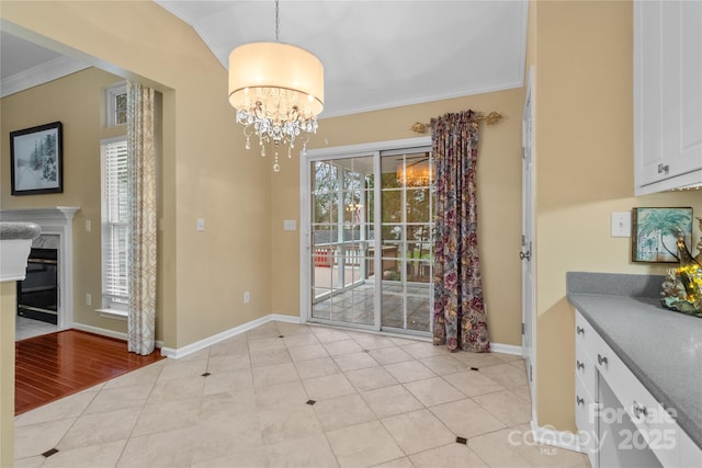 dining area featuring a fireplace, light tile patterned floors, ornamental molding, and a notable chandelier