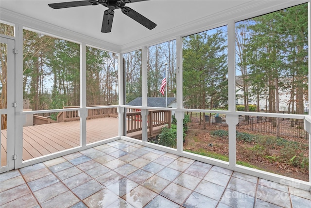 unfurnished sunroom featuring ceiling fan