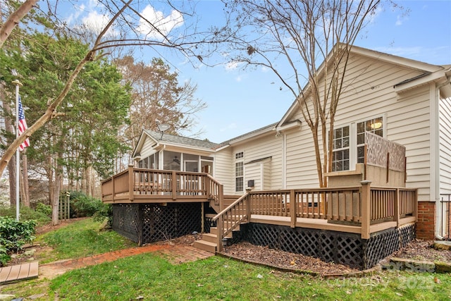 back of house with a deck, a lawn, and a sunroom