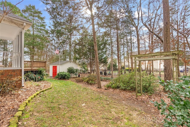 view of yard featuring a wooden deck and an outbuilding