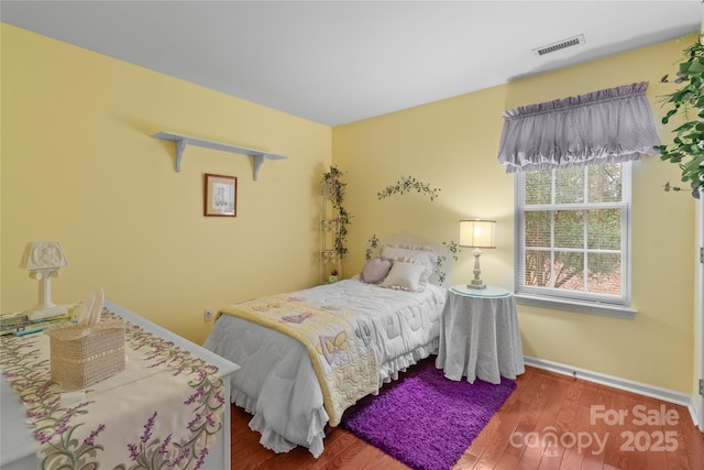 bedroom with dark hardwood / wood-style floors