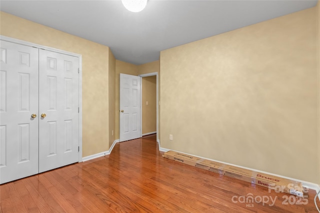 unfurnished bedroom with a closet and wood-type flooring