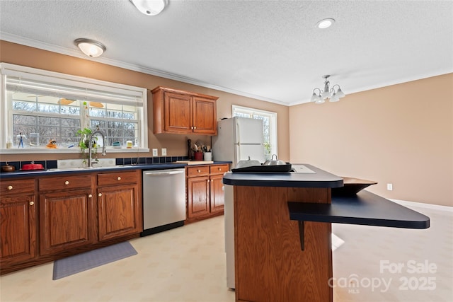 kitchen with a textured ceiling, white refrigerator, an inviting chandelier, dishwasher, and a kitchen island