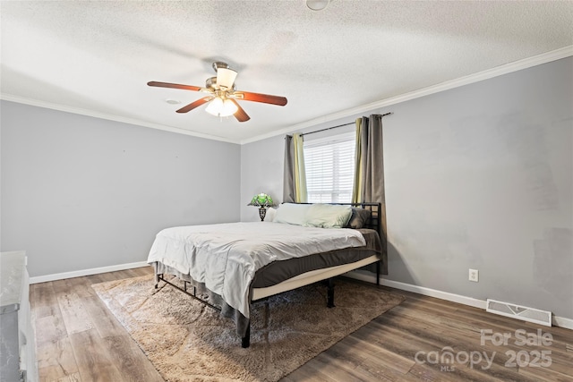 bedroom featuring wood-type flooring, a textured ceiling, ceiling fan, and ornamental molding