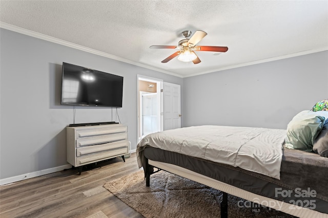 bedroom featuring a textured ceiling, hardwood / wood-style flooring, ceiling fan, and ornamental molding