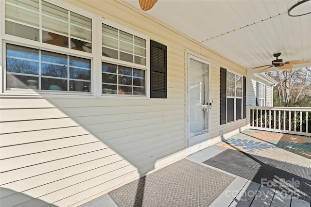 wooden terrace with ceiling fan and covered porch