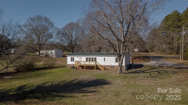 rear view of property with a lawn and a wooden deck