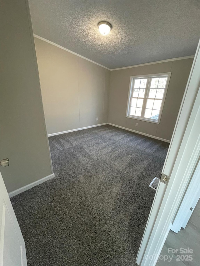 spare room with dark colored carpet and a textured ceiling