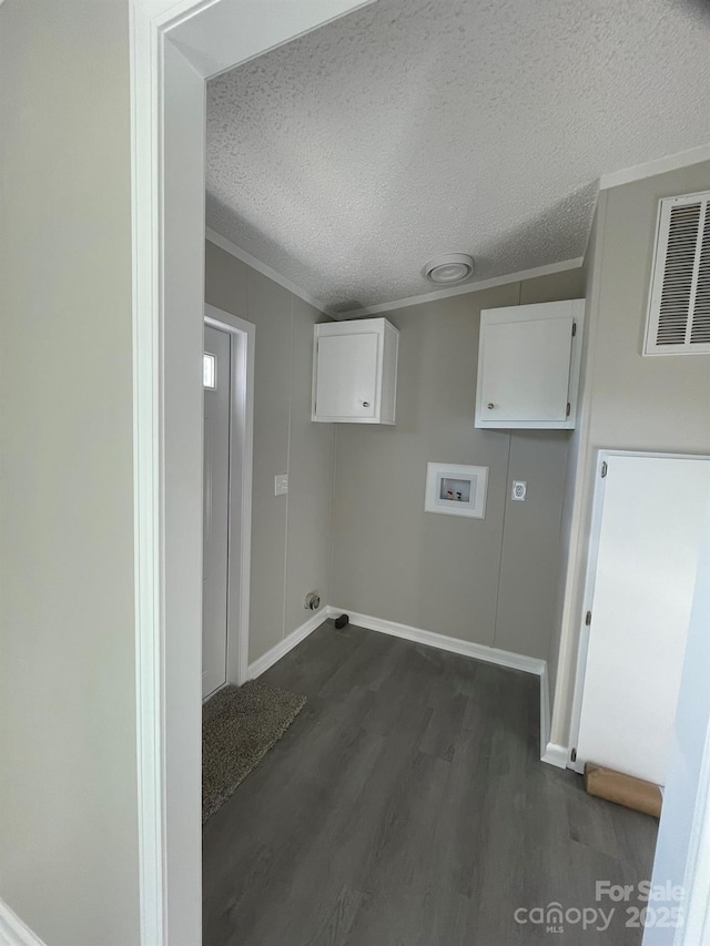 clothes washing area with washer hookup, cabinets, a textured ceiling, and dark wood-type flooring