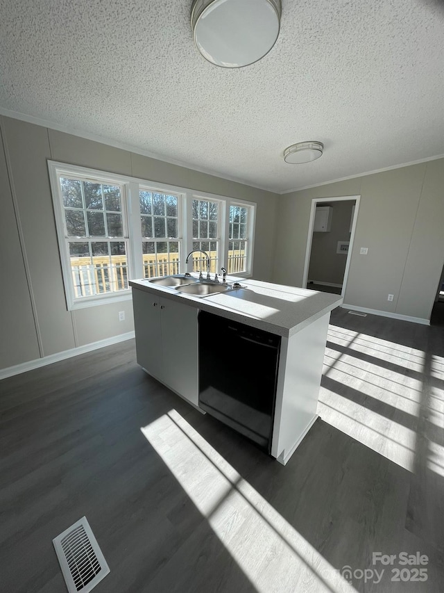 kitchen featuring a textured ceiling, dishwasher, dark hardwood / wood-style flooring, sink, and a kitchen island with sink