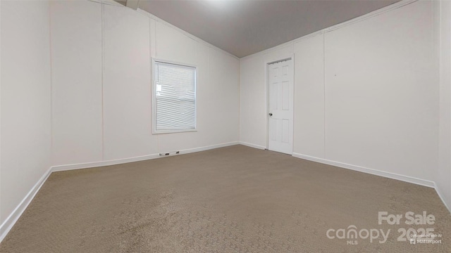 carpeted empty room featuring lofted ceiling