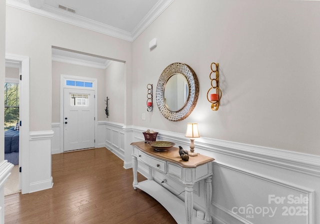 entrance foyer with wood-type flooring and ornamental molding