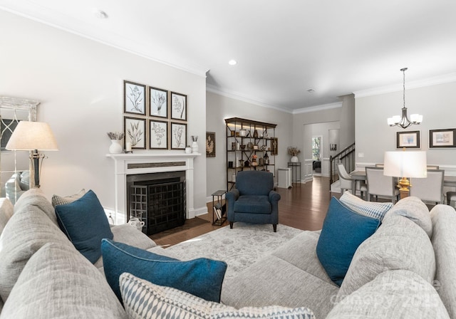 living room with hardwood / wood-style flooring, ornamental molding, and an inviting chandelier