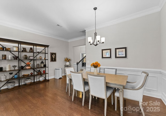 dining space featuring an inviting chandelier, dark wood-type flooring, and ornamental molding