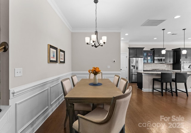 dining room with a notable chandelier, dark hardwood / wood-style floors, and ornamental molding