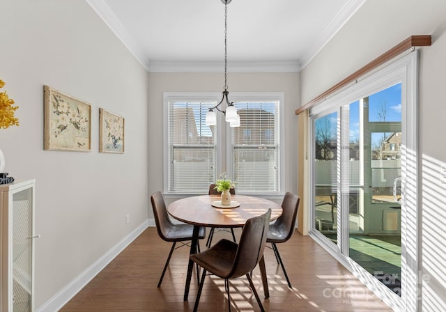 dining space featuring dark hardwood / wood-style flooring, an inviting chandelier, and ornamental molding