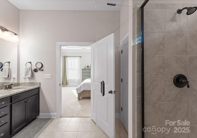 bathroom featuring a tile shower, vanity, and tile patterned floors